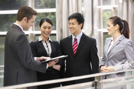 Four Business Colleagues Discussing Document Outside Officeの写真素材