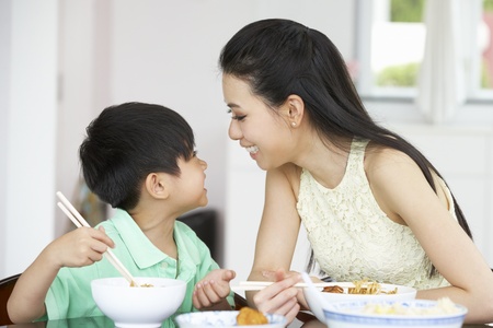 Chinese Mother And Son Sitting At Home Eating A Mealの写真素材