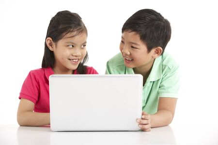 Studio Shot Of Two Chinese Children With Laptopの写真素材