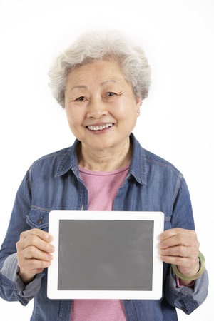 Studio Shot Of Chinese Senior Woman Holding Digital Tabletの写真素材