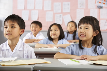 Group Of Students Working At Desks In Chinese School Classroomの写真素材