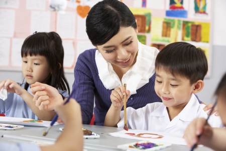 Teacher Helping Students During Art Class In Chinese School Classroomの写真素材