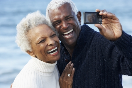 Senior Couple With Camera On Beachの写真素材