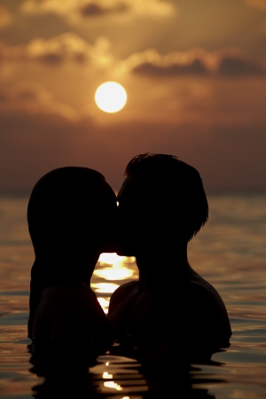 Silhouette Of Romantic Couple Standing In Seaの写真素材