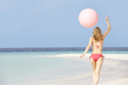 Woman In Bikini Running On Beautiful Beach With Balloonの写真素材