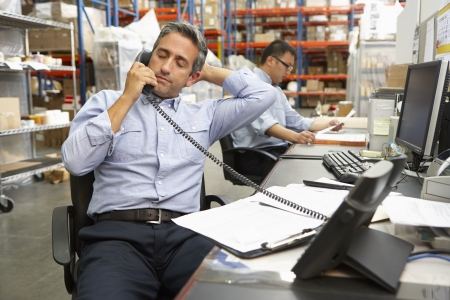 Businessman Working At Desk In Warehouseの写真素材
