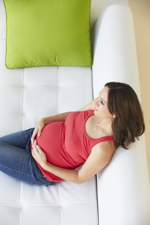 Overhead View Of Pregnant Woman Relaxing On Sofaの写真素材