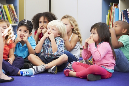Group of Elementary Pupils In Classroom Touching Nosesの写真素材