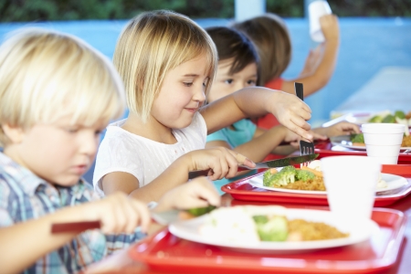 Elementary Pupils Enjoying Healthy Lunch In Cafeteriaの写真素材