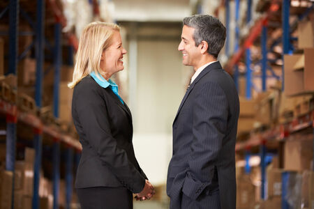 Businesswoman And Businessman In Distribution Warehouseの写真素材