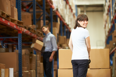 Businesswoman Pulling Pallet In Warehouseの写真素材