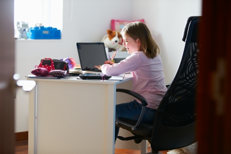 Girl Studying In Bedroom Using Laptopの写真素材