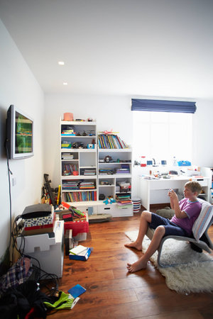 Boy Playing Video Game In Bedroomの写真素材