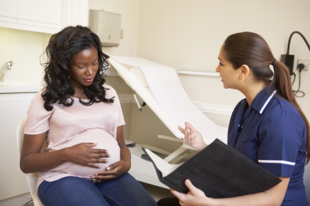 Pregnant Woman Being Given Ante Natal Check By Nurseの写真素材