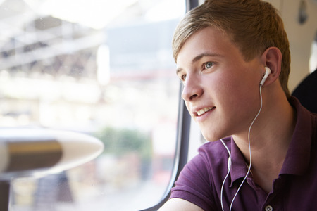 Young Man Listening To Music On Train Journeyの写真素材
