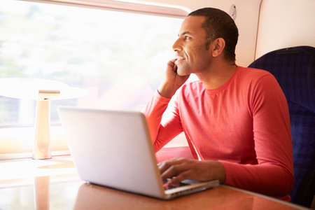 Man Using Laptop On Trainの写真素材