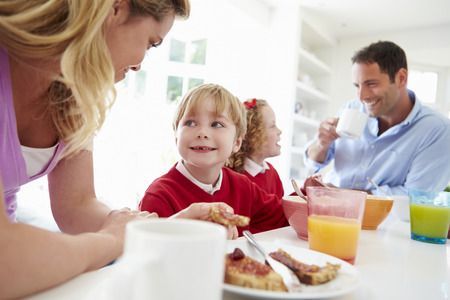 Family Having Breakfast In Kitchen Before Schoolの写真素材