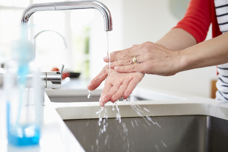 Close Up Of Woman Washing Hands In Kitchen Sinkの写真素材