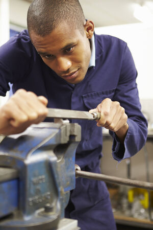 Engineer Using Metal File On Factory Floorの写真素材