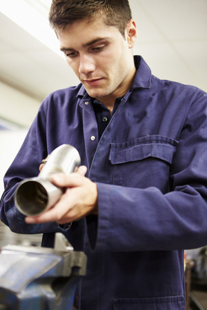 Apprentice Engineer Checking Component On Factory Floorの写真素材