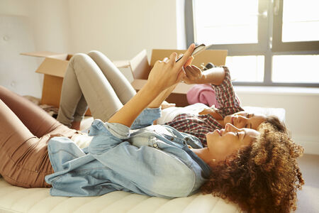 Two Women Moving Into New Home Using Digital Tabletの写真素材