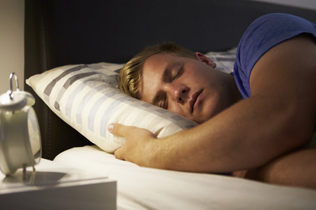 Teenage Boy Asleep In Bed At Night