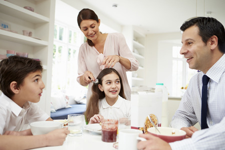 Family Having Breakfast Before Husband Goes To Workの写真素材