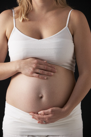 Close Up Portrait Of 5 months Pregnant Woman On Black Backgroundの写真素材