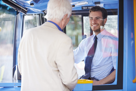 Senior Man Boarding Bus And Buying Ticket