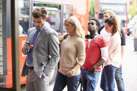 Queue Of People Waiting At Bus Stop