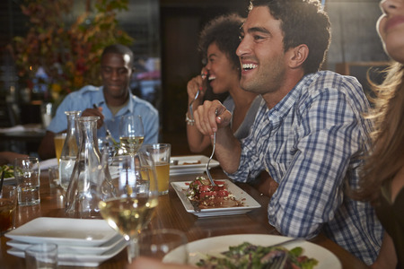 Group Of Friends Enjoying Meal In Restaurant Group Of Friends Enjoying Meal In Restaurant
