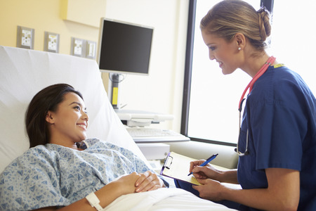 Nurse Talking To Female Patient On Wardの写真素材