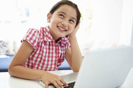 Asian Child Using Laptop At Home