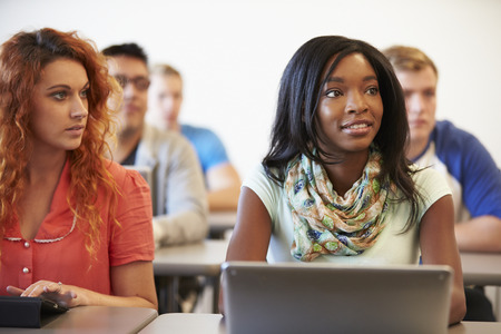 University Students Using Digital Tablet And Laptop In Class