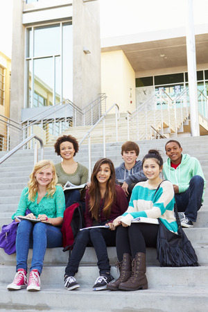 Portrait Of High School Students Sitting Outside Buildingの写真素材