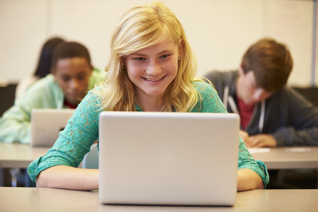 Female High School Student At Desk In Class Using Laptopの写真素材