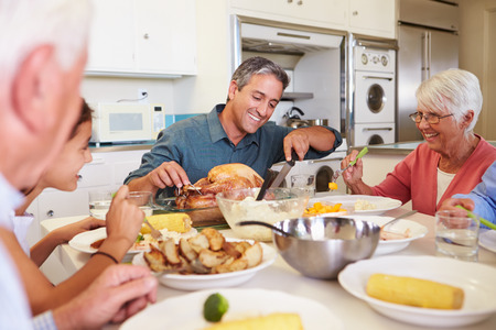 Multi-Generation Family Sitting Around Table Eating Mealの写真素材
