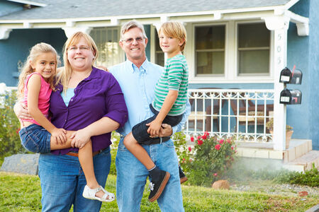 Portrait Of Family Outside Suburban House