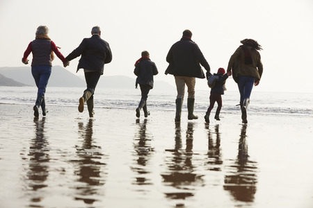 Multi Generation Family Walking On Winter Beachの写真素材