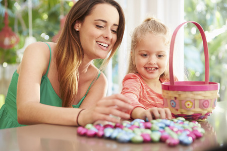 Mother And Daughter With Chocolate Easter Eggs And Basketの写真素材
