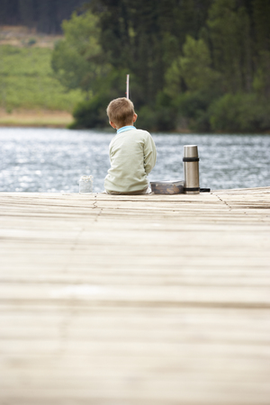 Young boy fishing on a jettyの写真素材