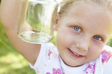 Little girl with cricket in a jarの写真素材