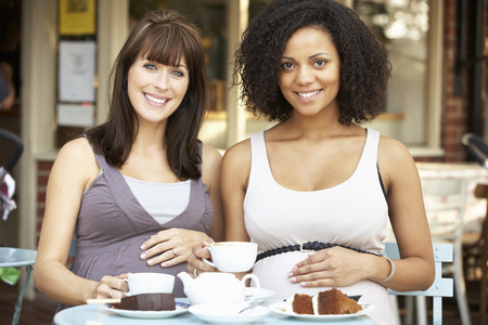 Pregnant women sitting outside caféの写真素材