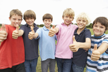 Portrait group of boys doing thumbs up in parkの写真素材