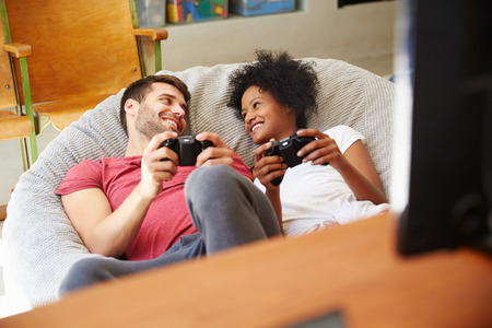 Young Couple In Pajamas Playing Video Game Together