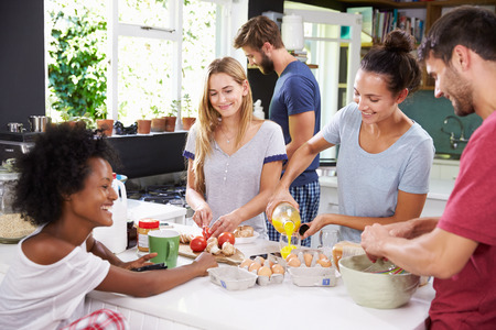 Group Of Friends Cooking Breakfast In Kitchen Togetherの写真素材
