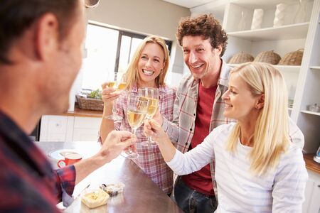 Four friends celebrating at homeの写真素材
