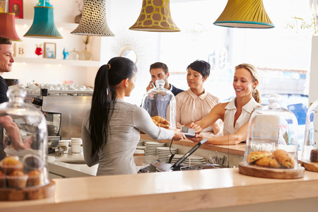 Woman paying for her order in a cafeの写真素材
