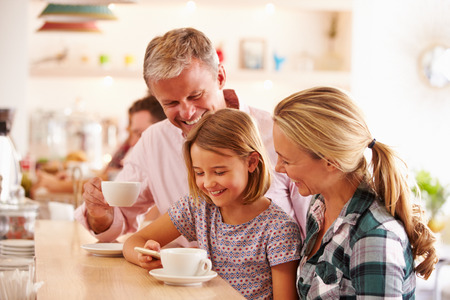 Happy family in a cafeの写真素材