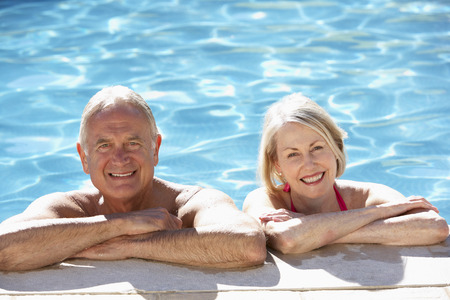 Senior Couple Relaxing In Swimming Pool Togetherの写真素材